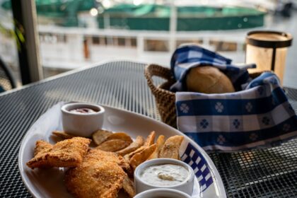 a plate of food on a table with a view of a harbor