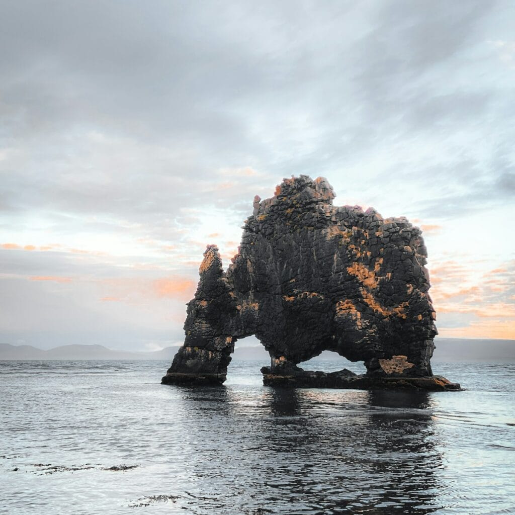 a rock formation in the middle of a body of water
