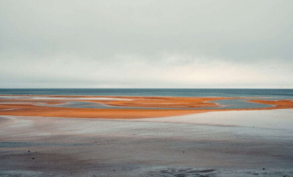 a large body of water sitting on top of a sandy beach