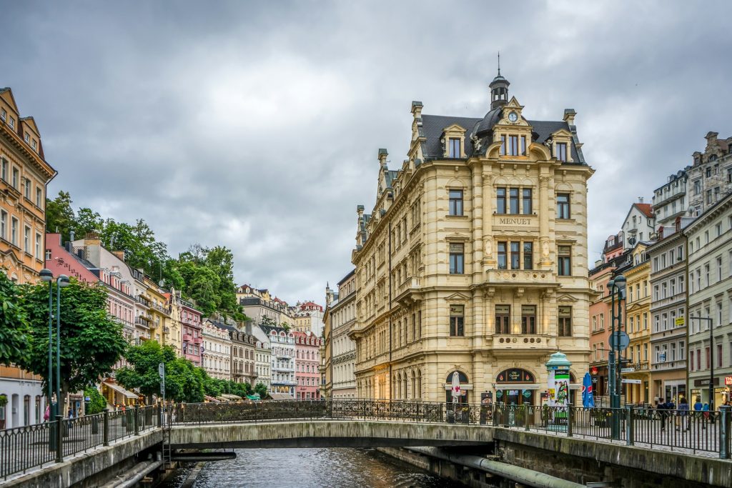 Karlovy Vary brown concrete building near bridge under white sky during daytime