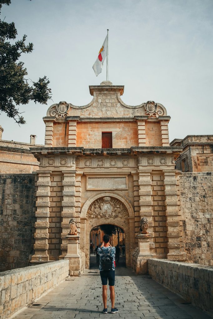 Mdina, a person standing in front of a stone building