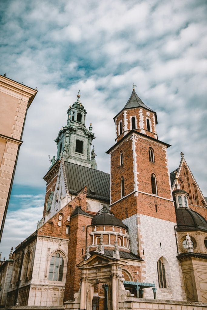 Wawel, Kraków brown and gray concrete building under blue sky during daytime