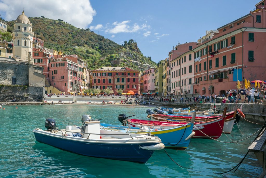 white and blue boat on water near buildings during daytime
