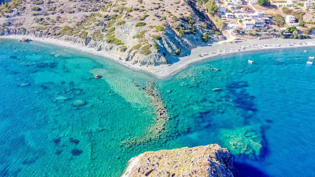aerial view of green and brown mountain beside blue sea during daytime