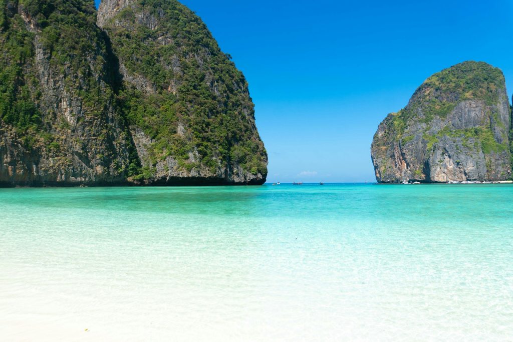 A beach with several large rocks in the water
