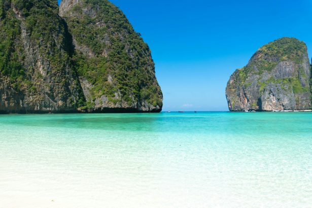 A beach with several large rocks in the water