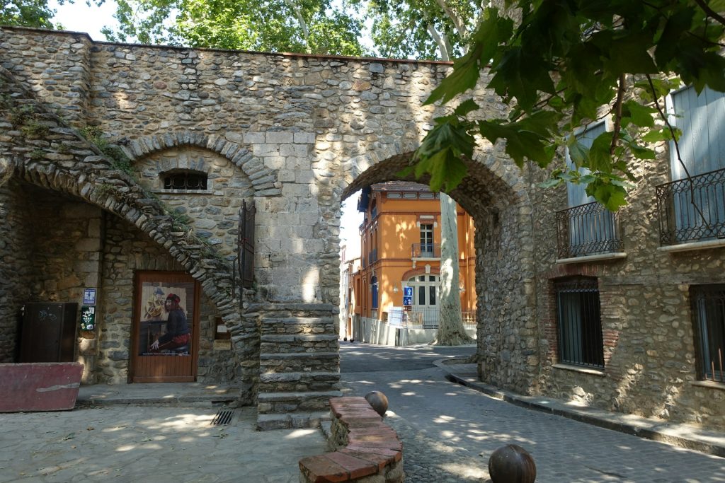 Stone archway with stairs and a street view of buildings
