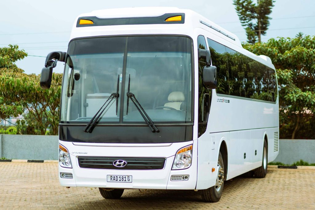 Front view of a modern white bus parked in an outdoor setting.