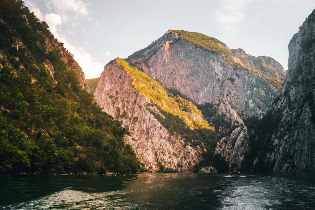 Breathtaking landscape of Lake Koman surrounded by steep rocky mountains in summer.