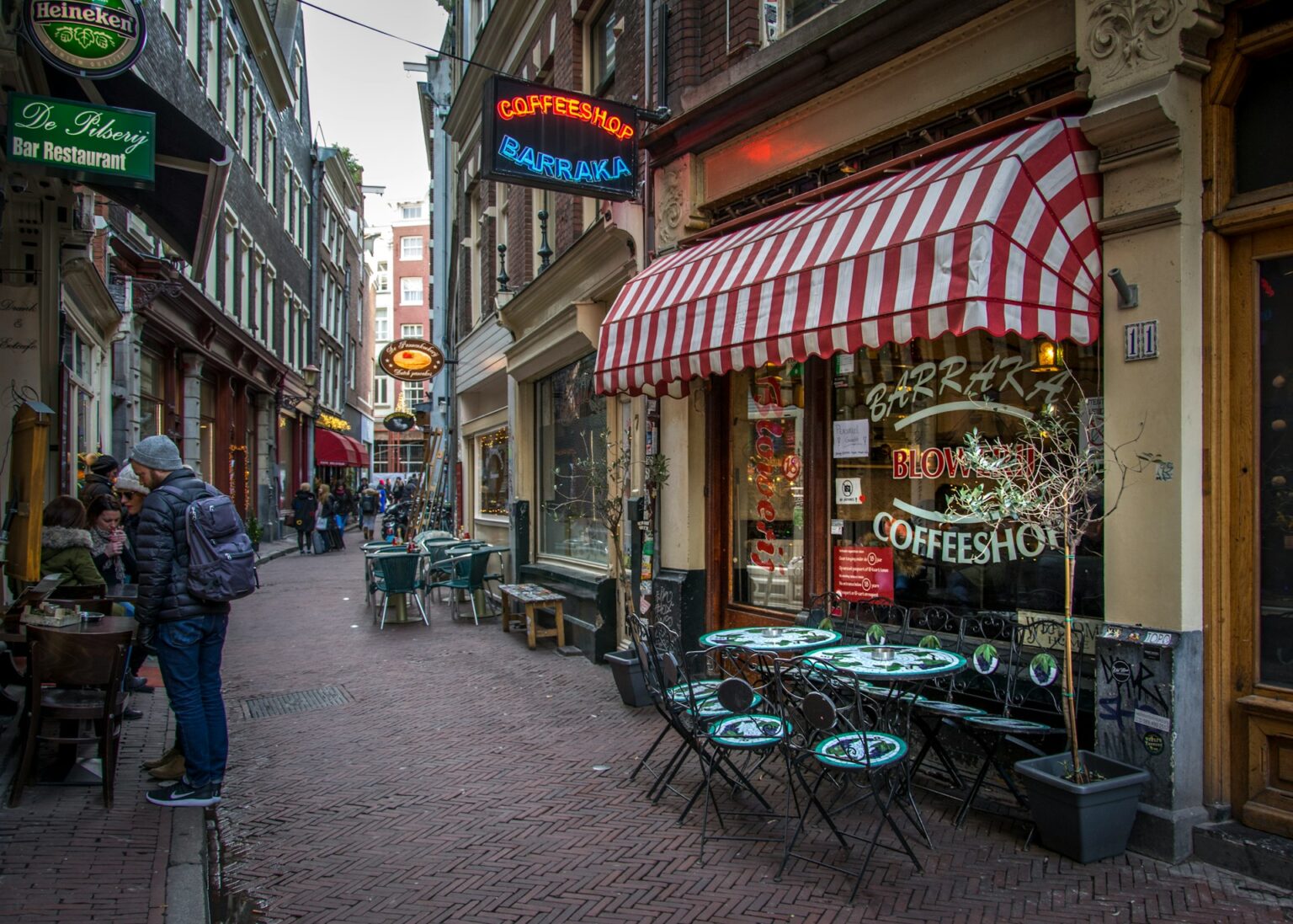 a sidewalk with tables and chairs on it