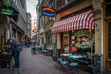 a sidewalk with tables and chairs on it