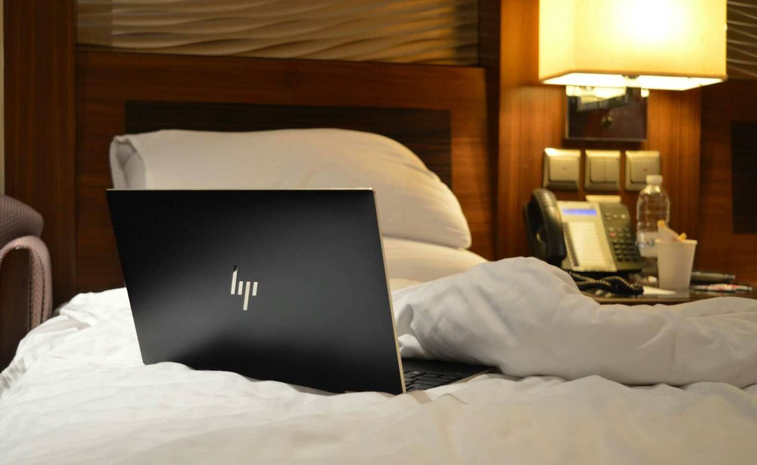 laptop leżący na łóżku